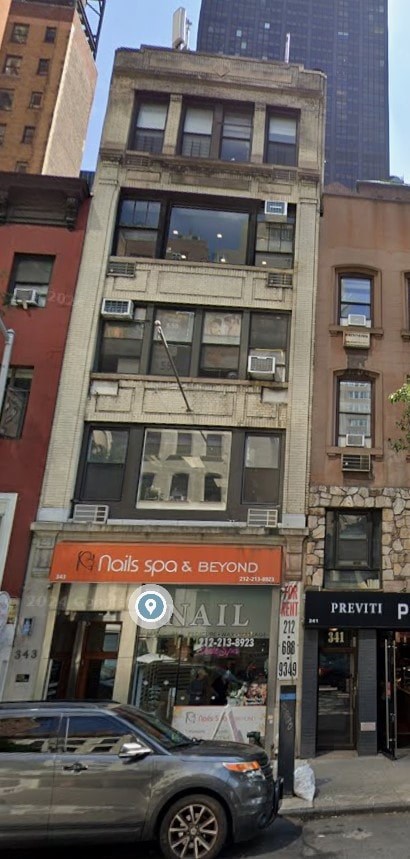 a car is parked in front of a tall building