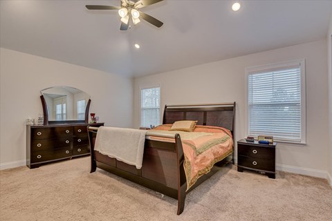 a bedroom with a bed and a ceiling fan