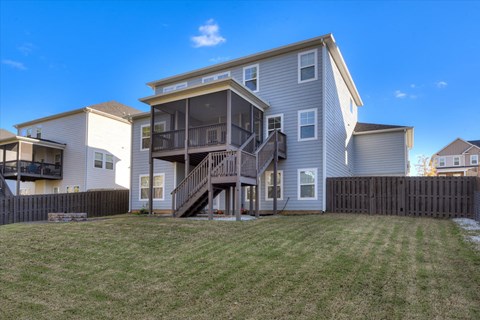 the back of a house with stairs and a yard