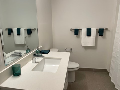 A bathroom with a white counter top and a white toilet.