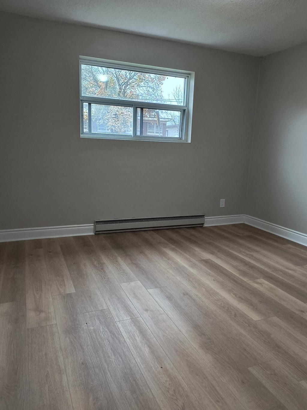 A room with a window and a radiator on the wall.