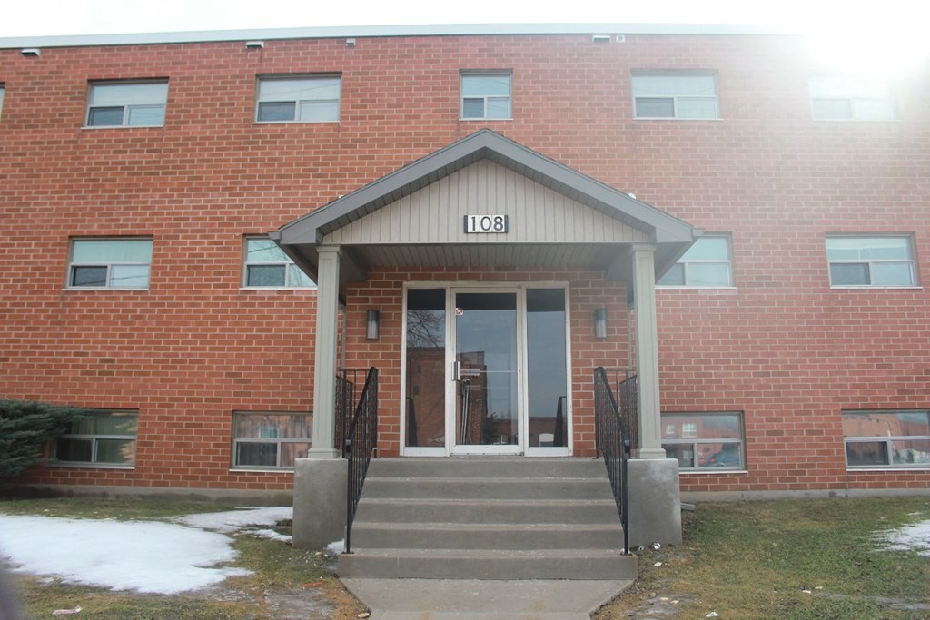 The front of a red brick building with the number 108 on it.
