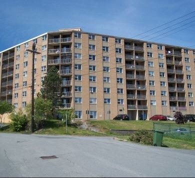 A large apartment building with a parking lot in front.