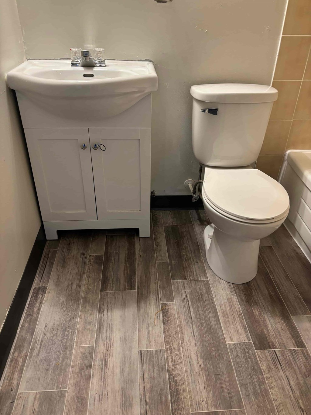 A white toilet sits next to a sink in a bathroom.