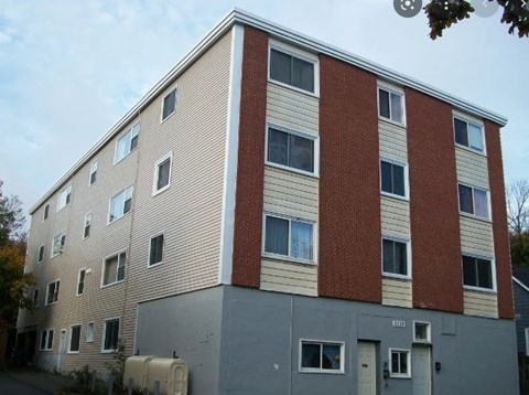 A multi-story building with a mix of beige and red brick facades.