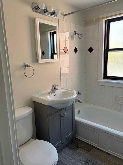 A bathroom with a white toilet, a sink, and a bathtub.