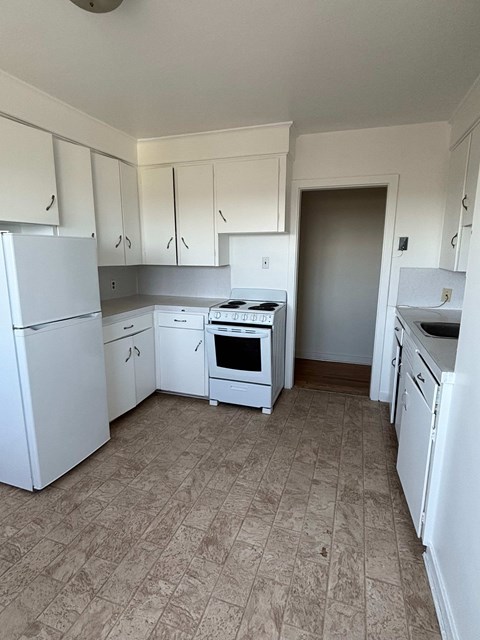 A kitchen with white appliances and cabinets.
