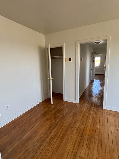 A room with a white wall and a wooden floor.