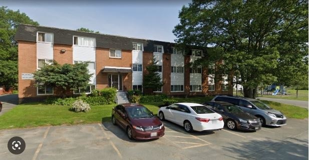 A parking lot with cars and a building in the background.