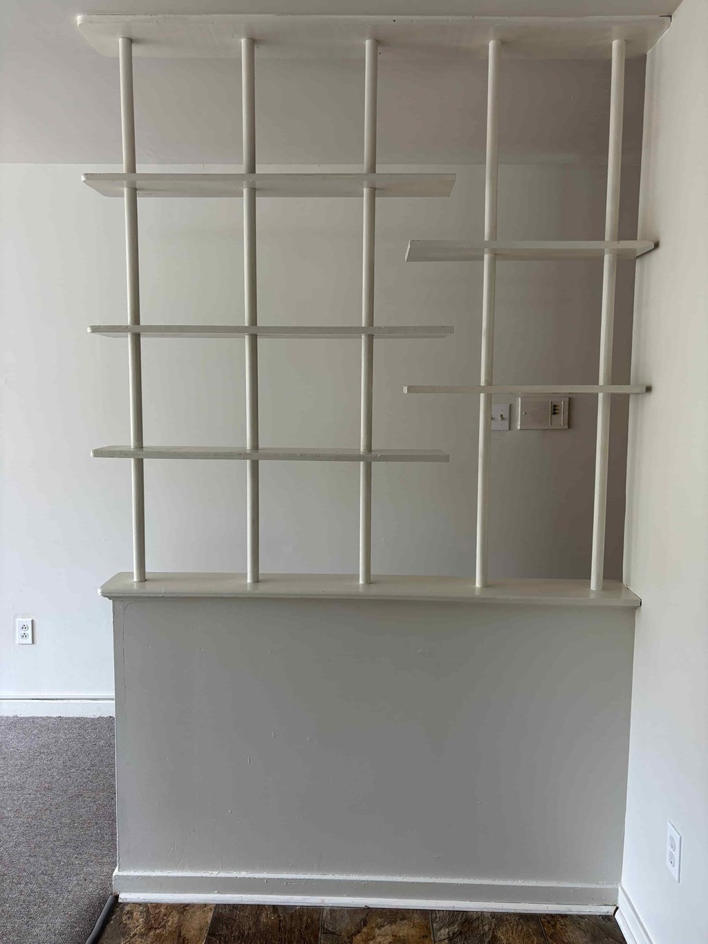A white shelving unit with glass doors and metal supports.