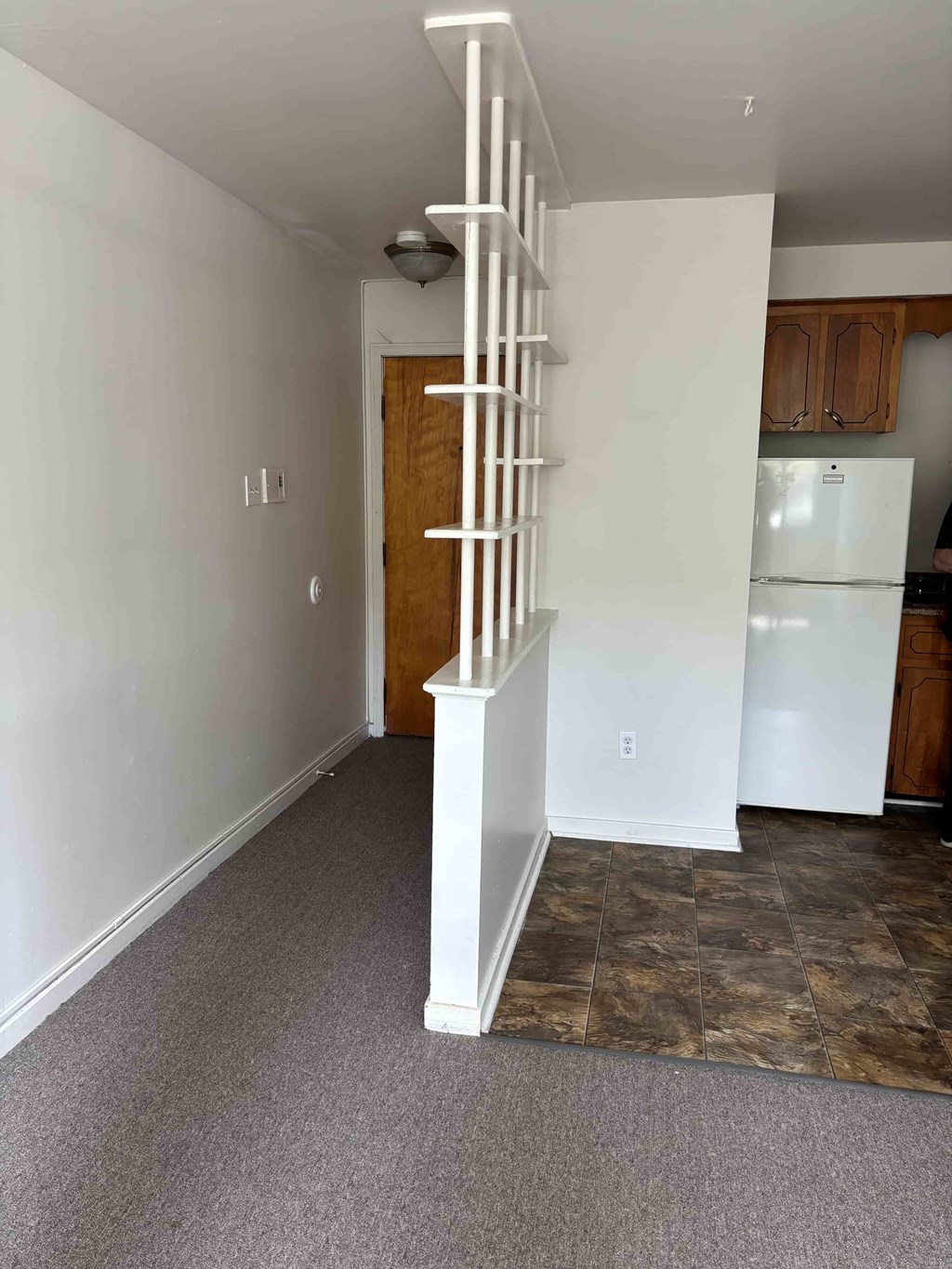 A white staircase with a wooden door at the bottom.