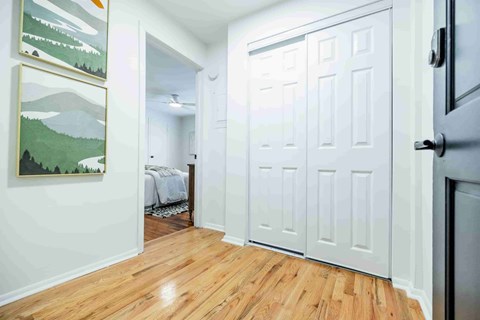 A room with a white door and a painting on the wall.