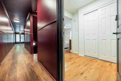A long hallway with wood floors and white doors.