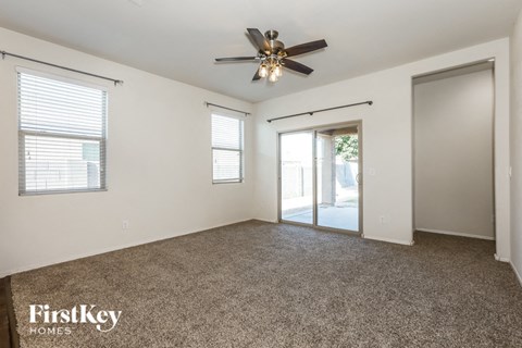 A spacious room with a ceiling fan and sliding glass doors.