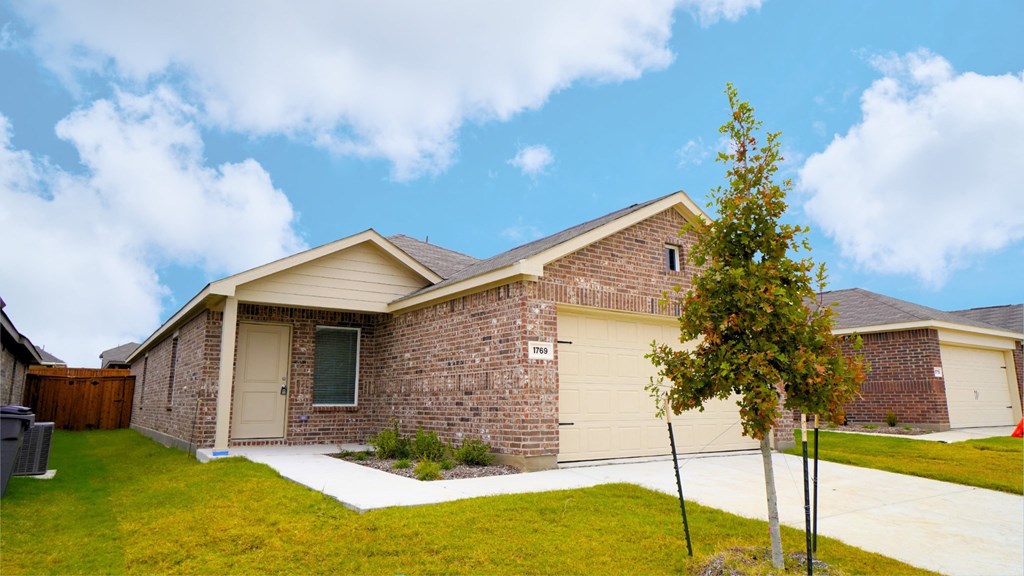 A house with a brown brick exterior and a white garage door.