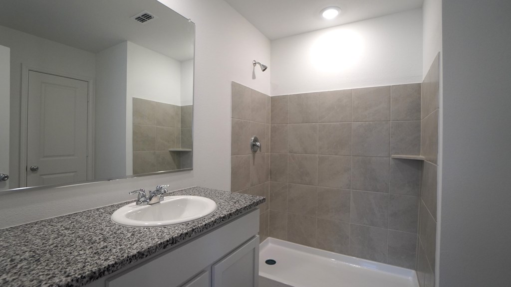 A bathroom with a sink, mirror, and tub.