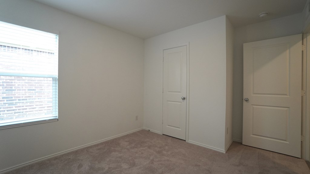 A room with a window, a door, and a wall.