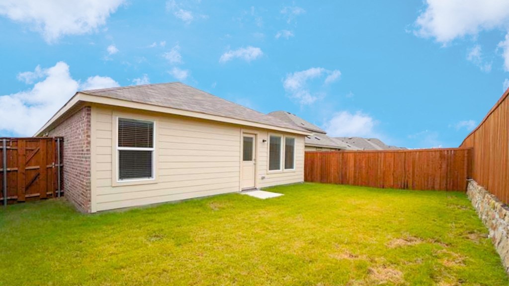 A house with a brown fence and a green lawn.