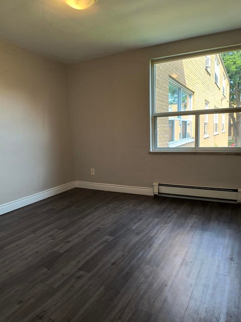 A room with a window and a radiator on the floor.