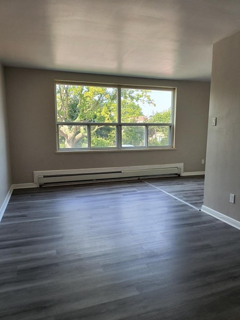 A room with a window and a radiator on the wall.