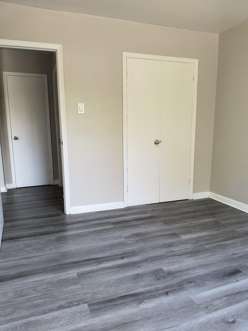 A room with a white door and a white closet.