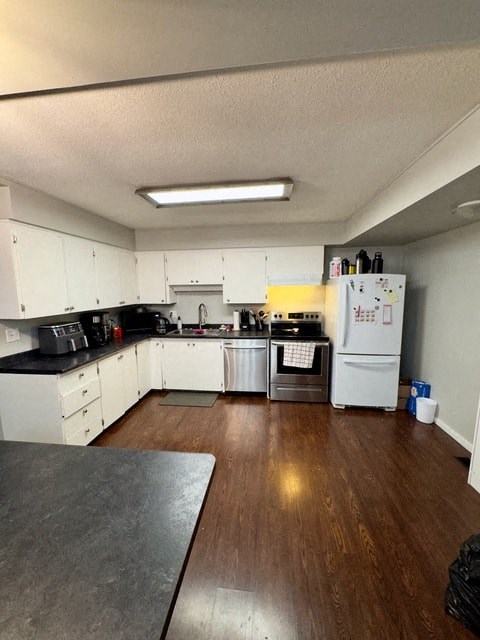 a kitchen with white cabinets and a stove and a refrigerator