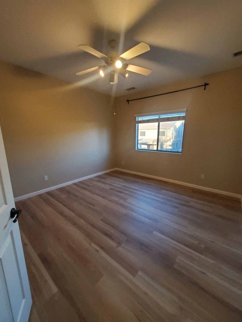 a living room with hardwood floors and a ceiling fan
