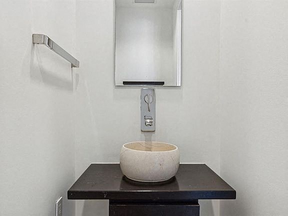 a bathroom with a bowl sink and a mirror