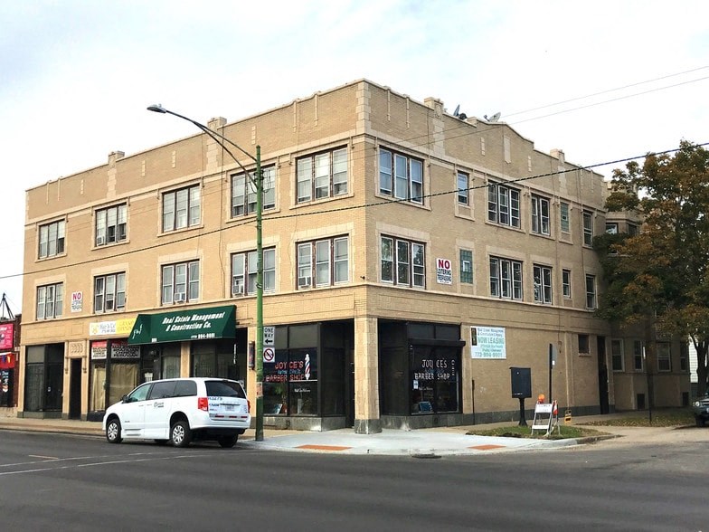 a building on the corner of a street with a white car