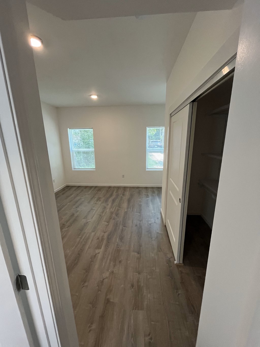 a renovated living room with hardwood floors and a closet