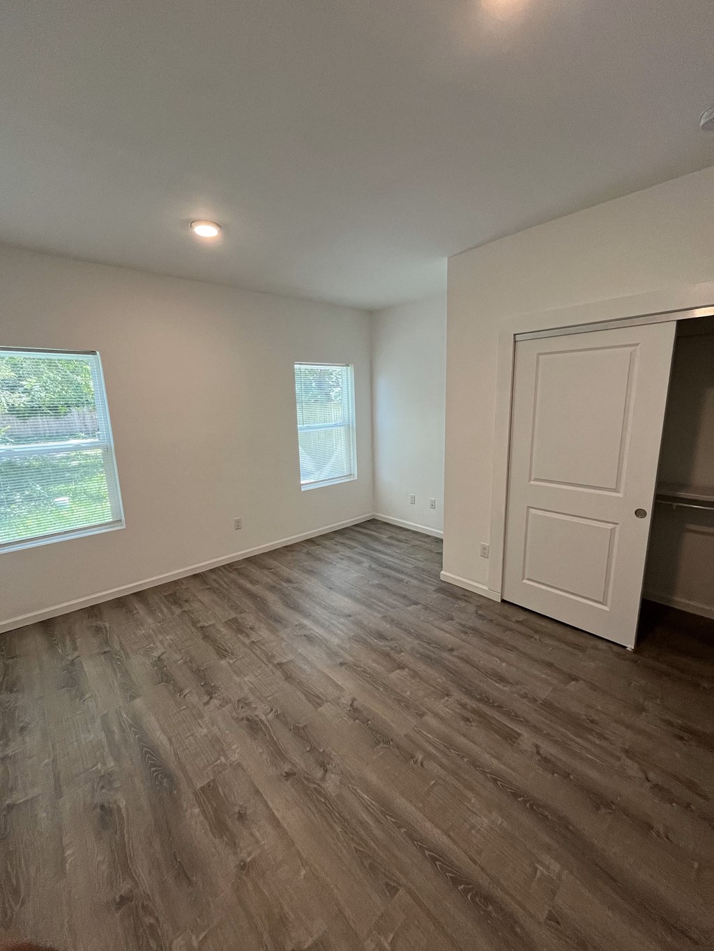 an empty living room with wood floors and a white door