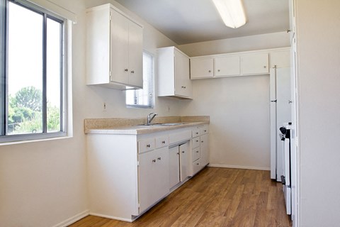 A kitchen with white cabinets and a window.