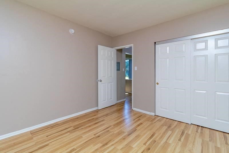 A room with a white door and a wooden floor.