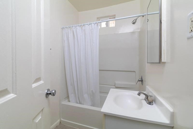 a bathroom with a sink and a shower and a curtain