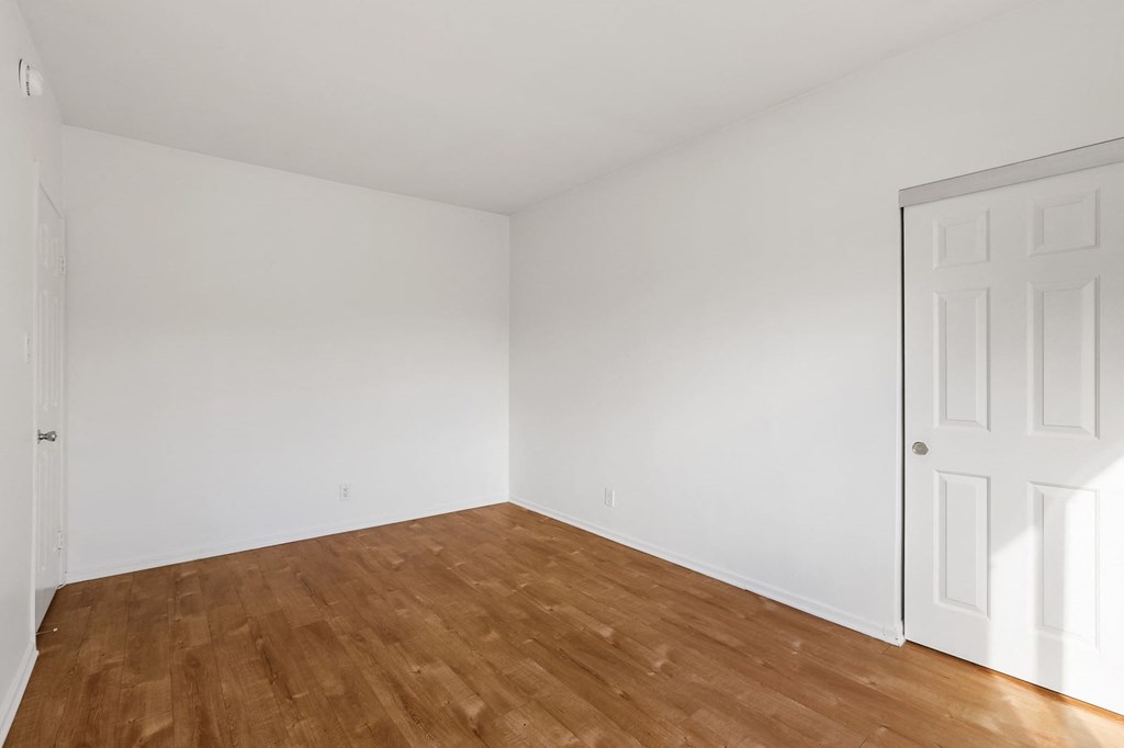 A room with wooden floors and white walls.