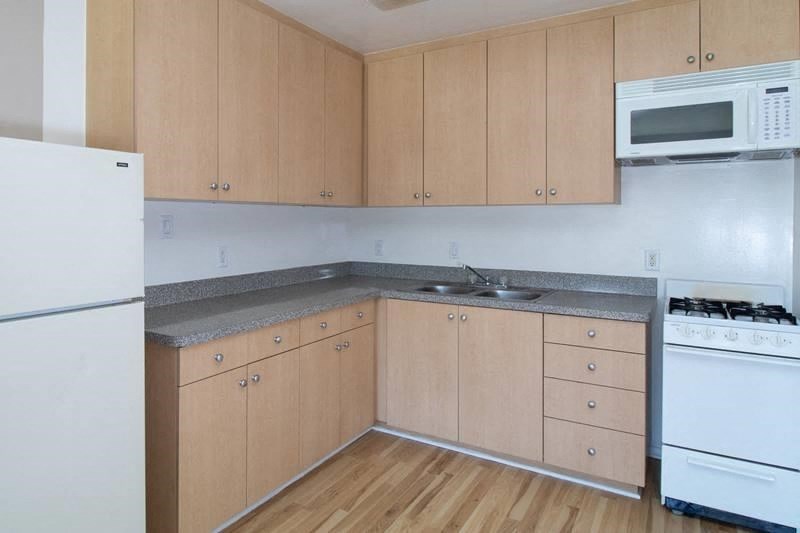 A kitchen with wooden cabinets and white appliances.
