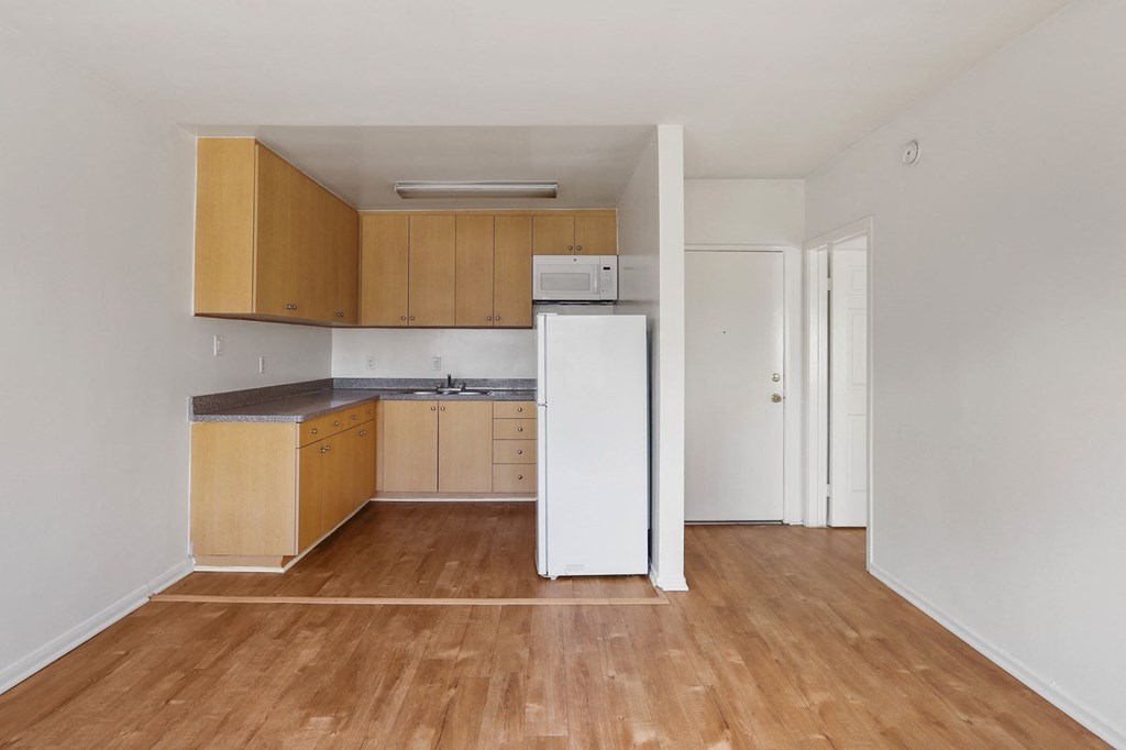 A kitchen with wooden floors and white walls.