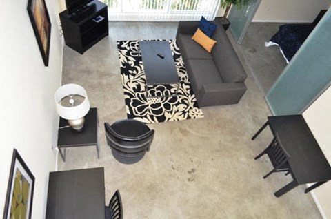 an aerial view of a living room with a couch and tables