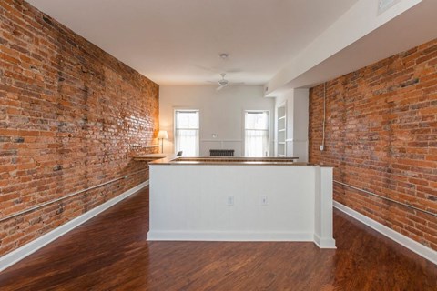 A room with a brick wall and wooden flooring.