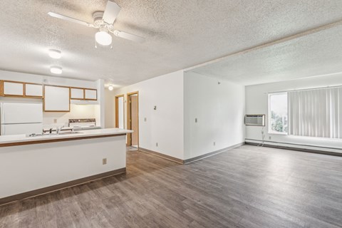 A room with a bar counter and a window with blinds.