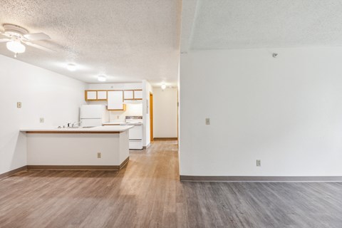 A kitchen with white cabinets and a wooden floor.