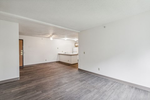 A room with a wooden floor and a white wall.