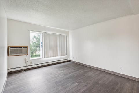 A room with a window and a wooden frame on the window.