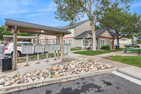 A parking lot with a shelter and a few cars.