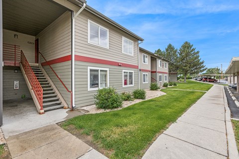 A building with a red stripe on the side and a staircase with red railings.