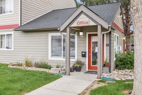 A small building with a red door and a sign that says "Office" on it.