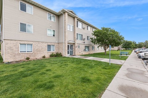 A residential building with a green lawn in front.