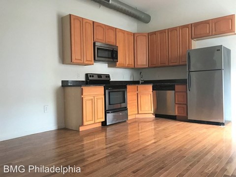 A kitchen with wooden cabinets and a black refrigerator.