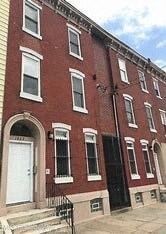 A red brick building with a black door and windows.