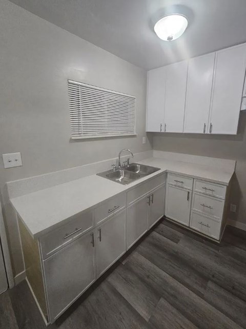 A kitchen with white cabinets and a sink.